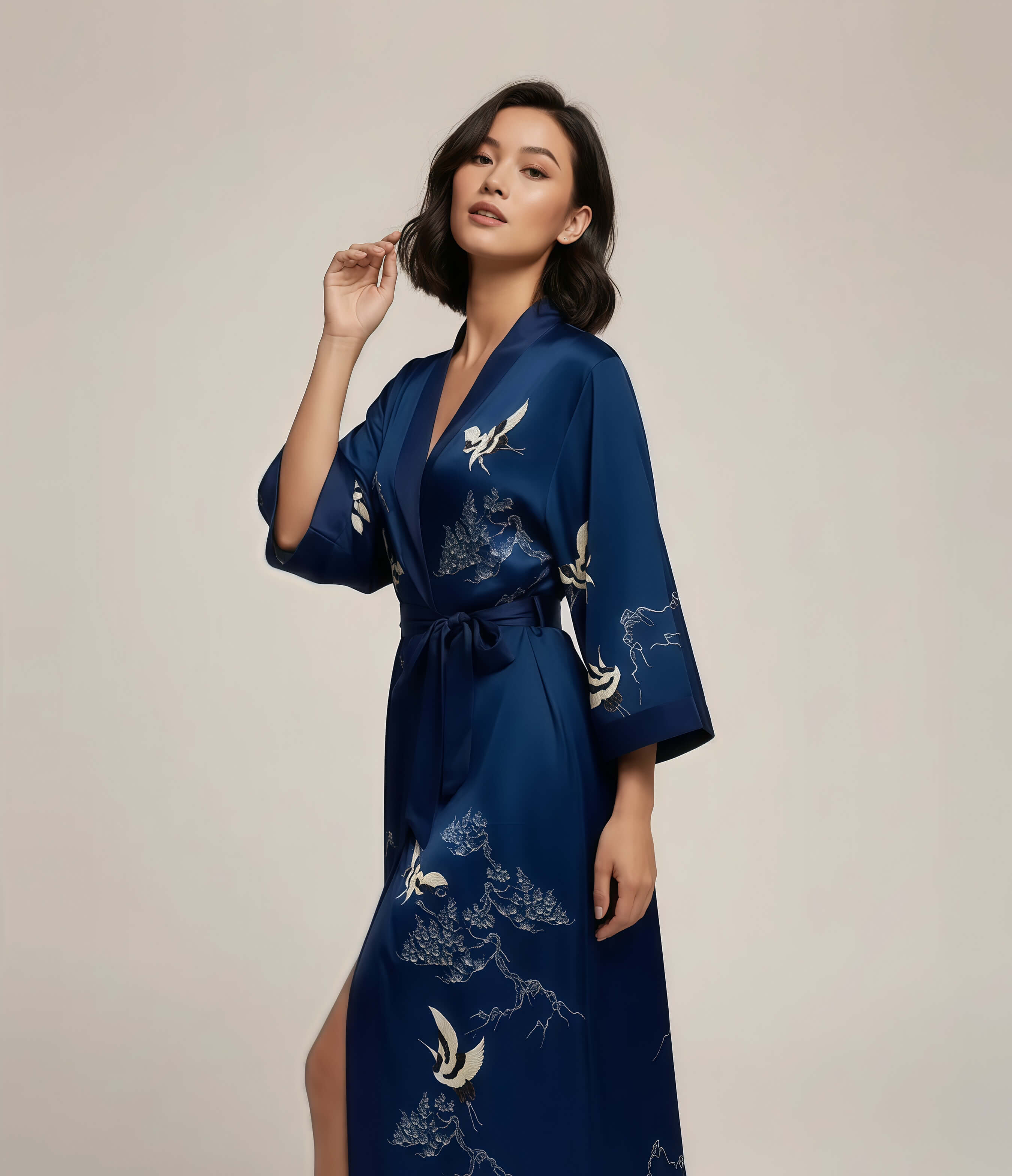 Close view of a blue Japanese kimono robe for women with white crane pattern, elegant long loungewear robe with waist belt.