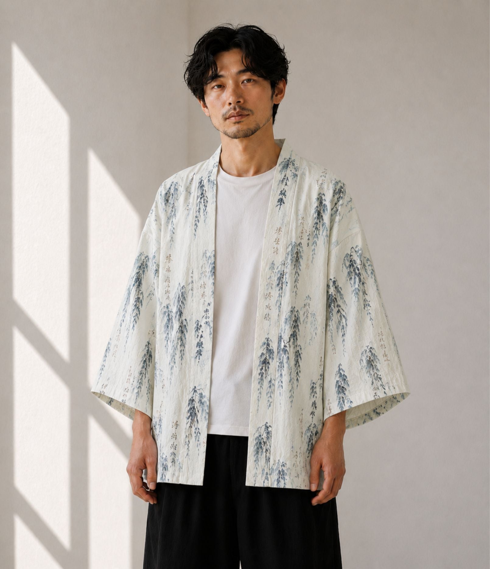 Man wearing an ivory willow and calligraphy print kimono cardigan over a white tee