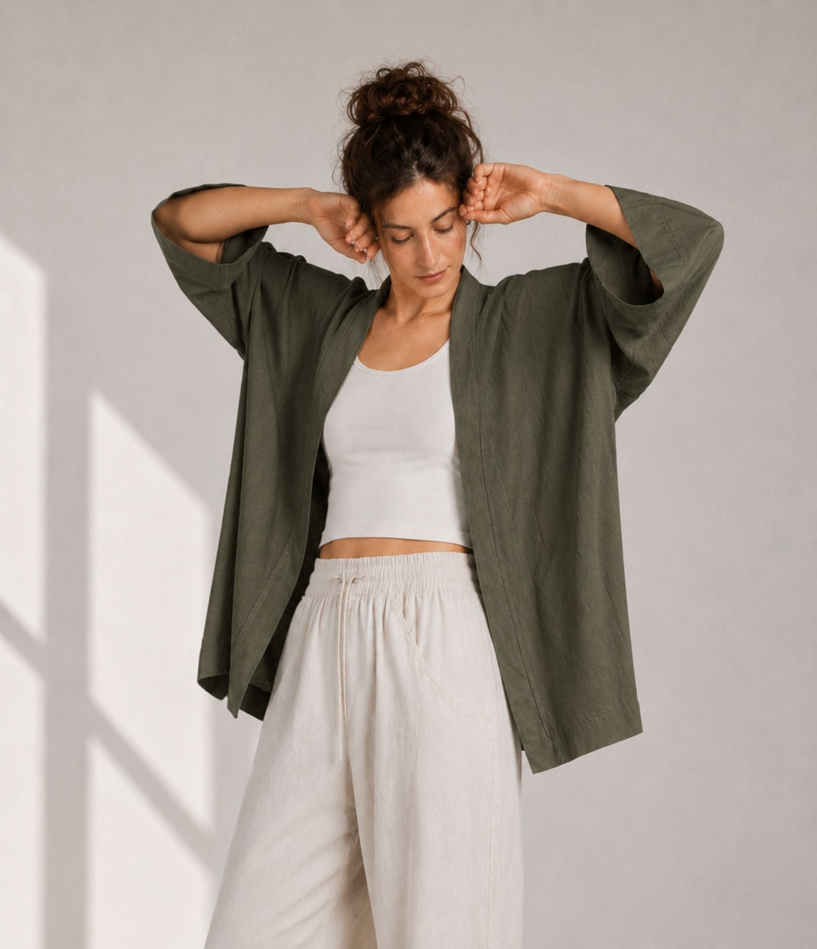 Woman showing the wide three-quarter sleeves of an olive green modern haori jacket