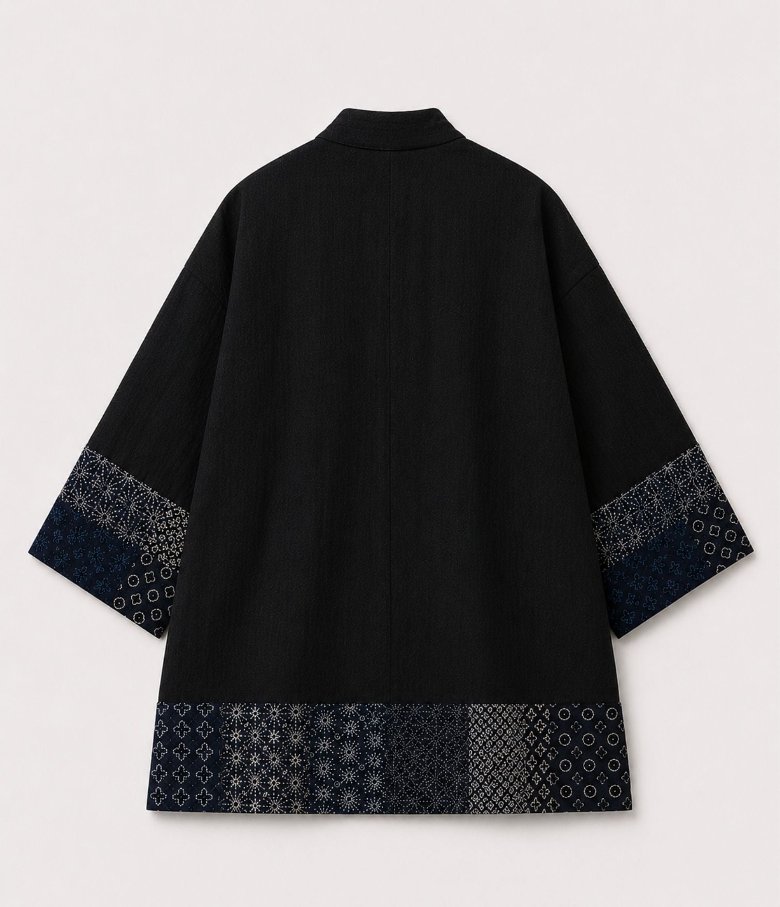 Back of a black kimono jacket with indigo sashiko-style patchwork trim