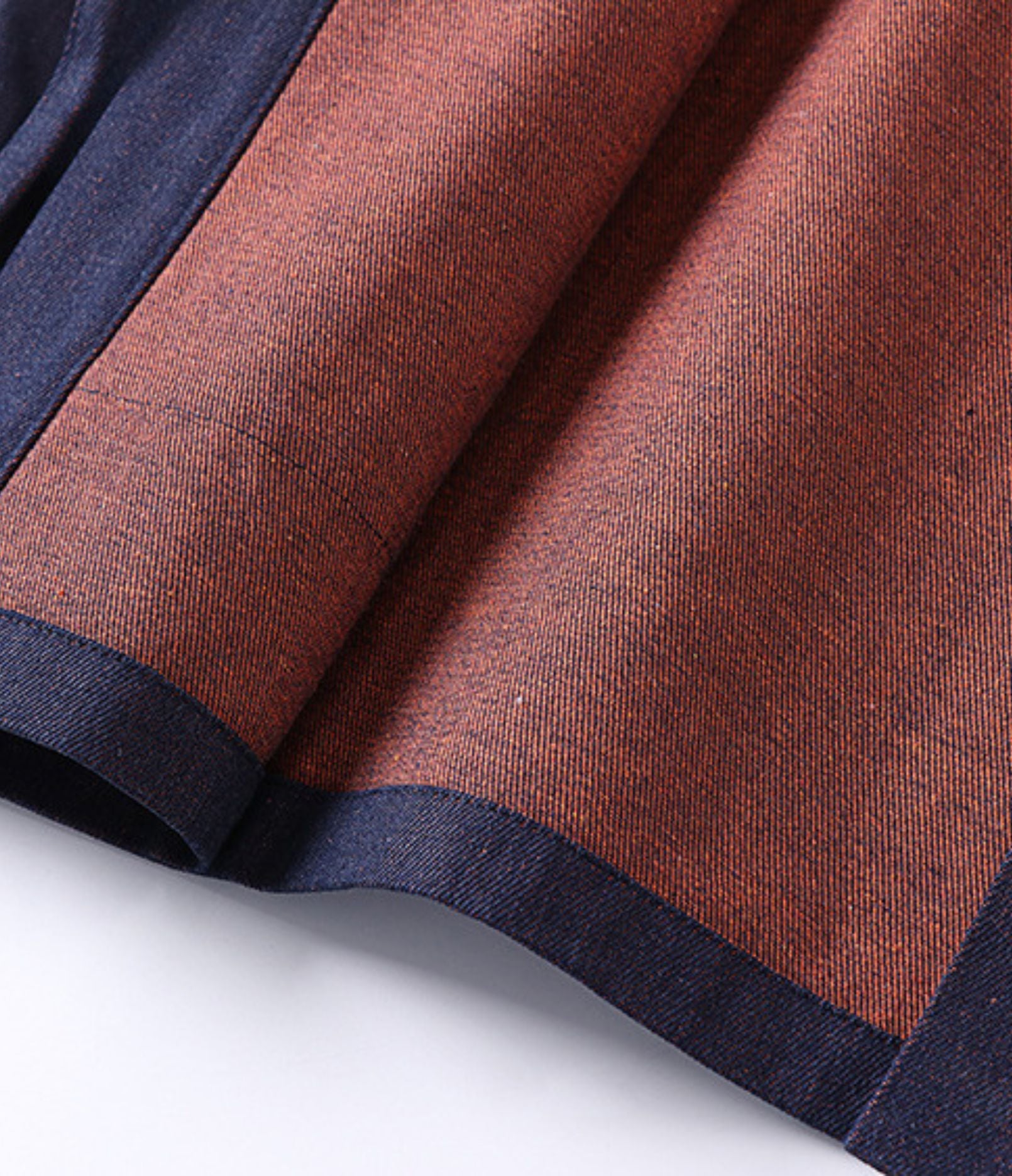 Close-up of rust fabric and navy contrast trim on the reversible haori