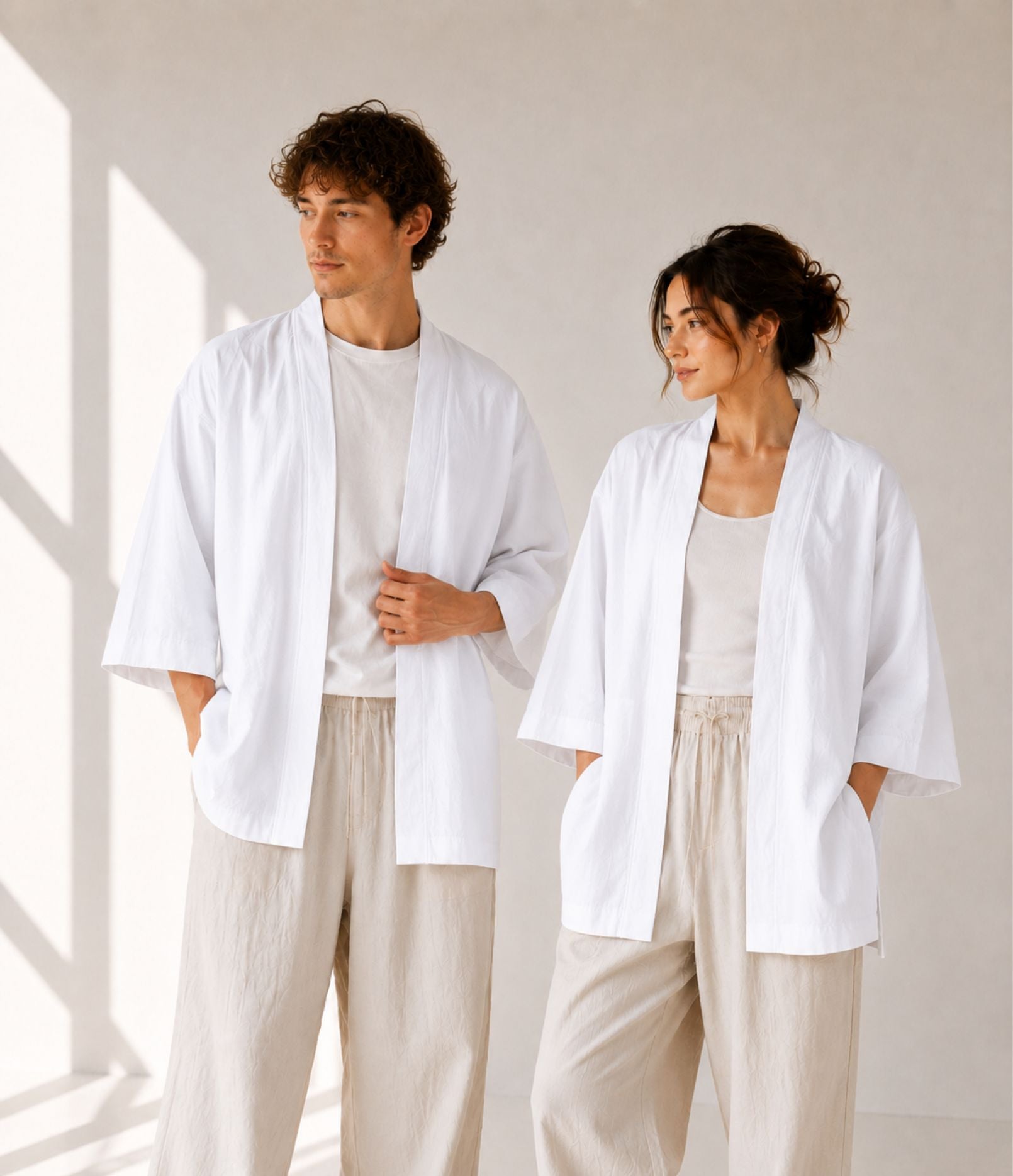 Man and woman wearing matching white unisex haori jackets with linen trousers