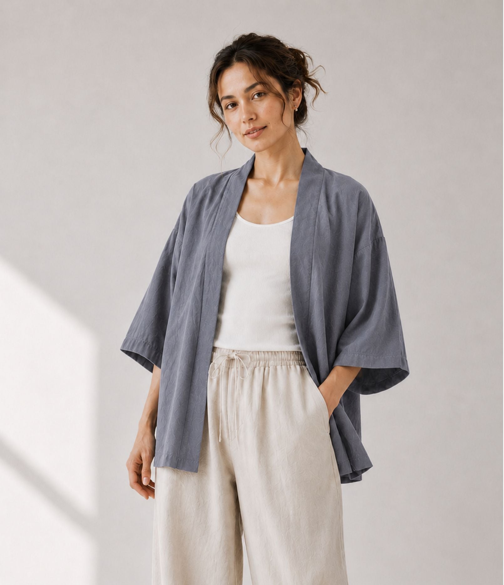 Woman wearing a lightweight grey haori jacket over a white tank top