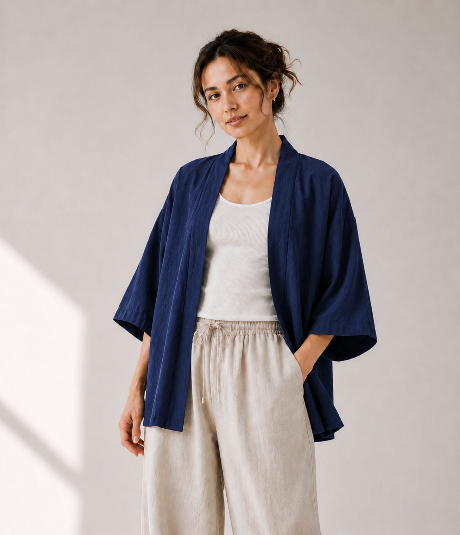 Woman wearing a lightweight navy haori jacket over a white tank top