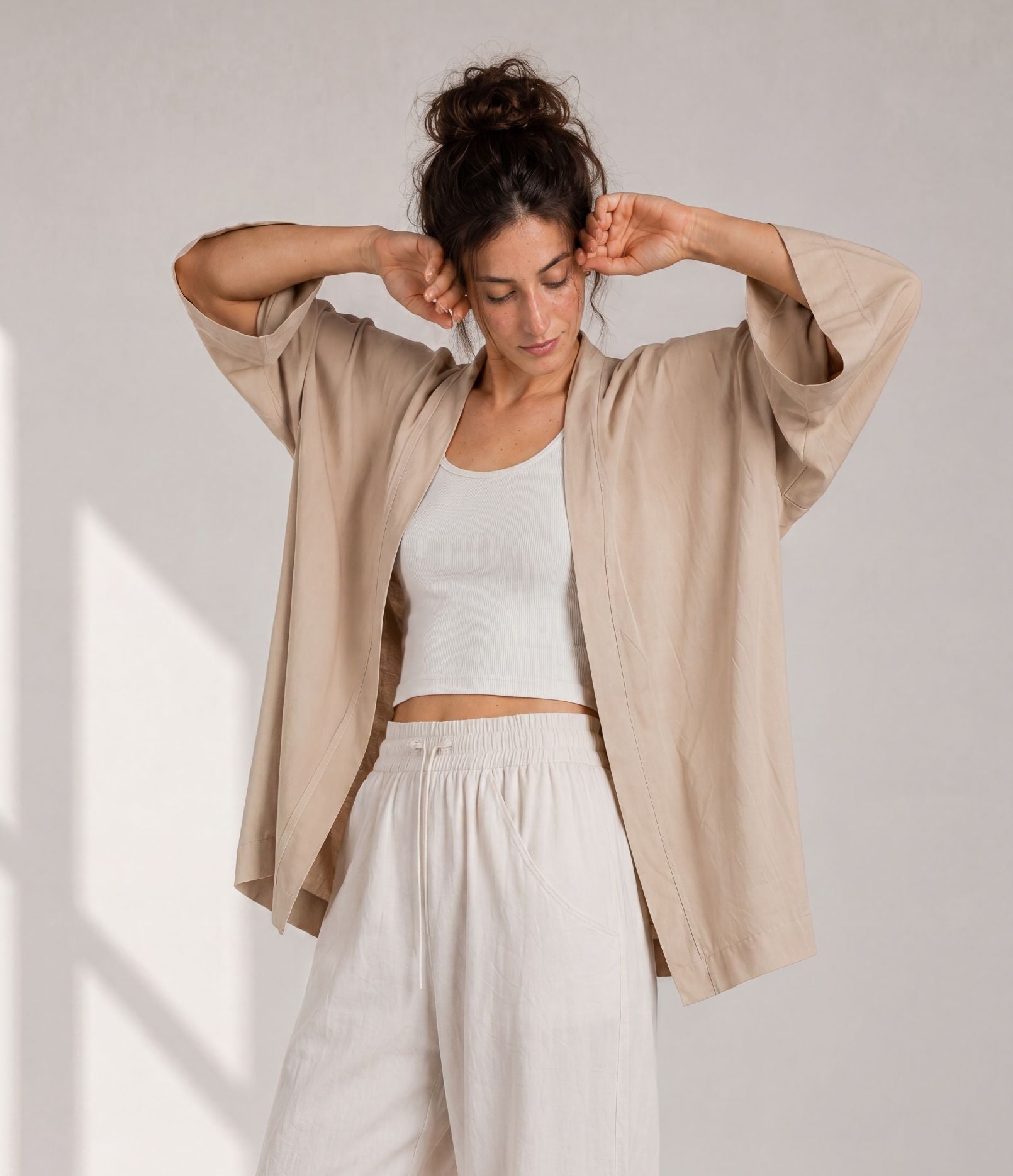 Woman showing the wide sleeves of a sand beige haori jacket