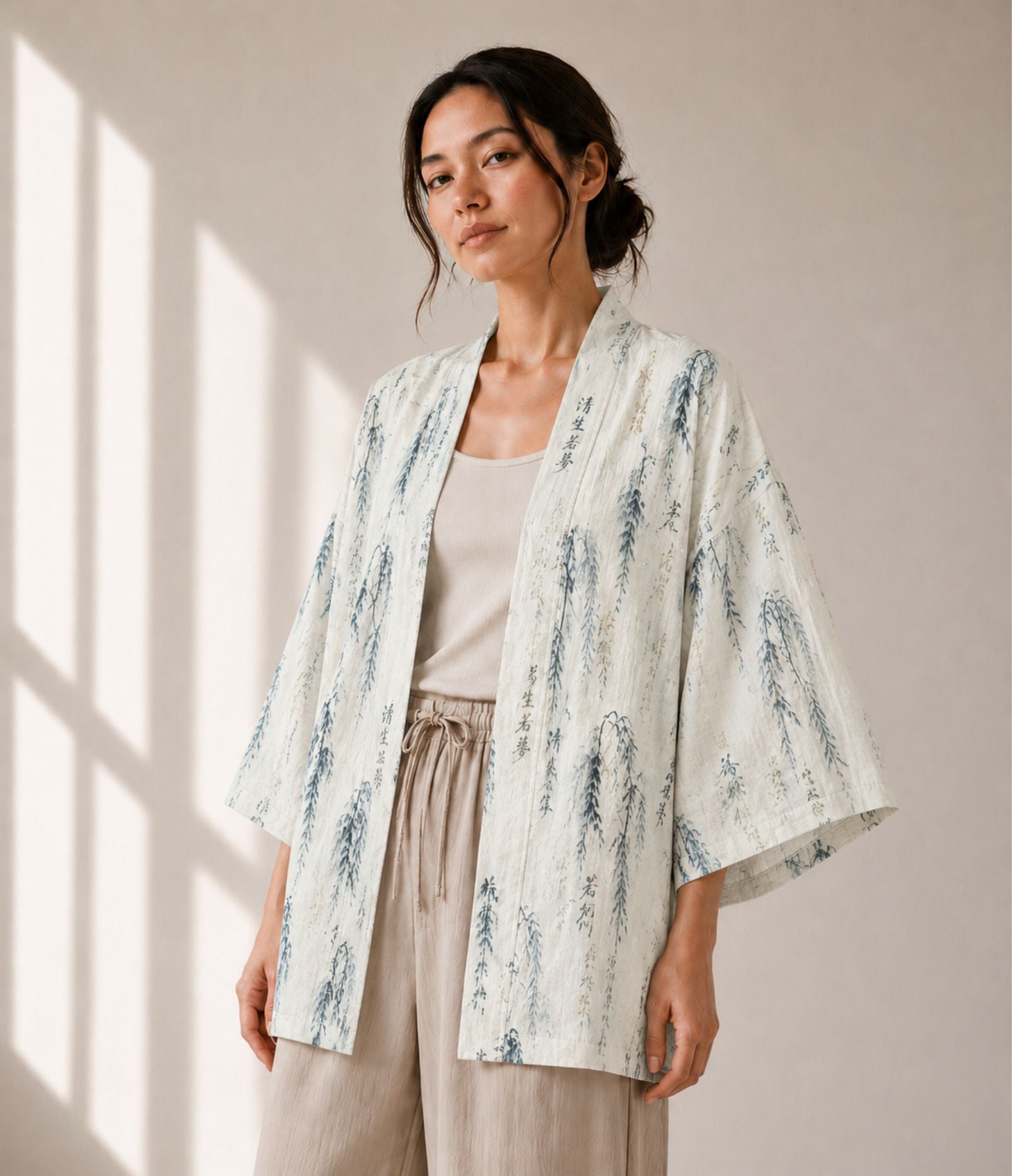 Woman wearing an ivory willow-print haori jacket over a beige tank top