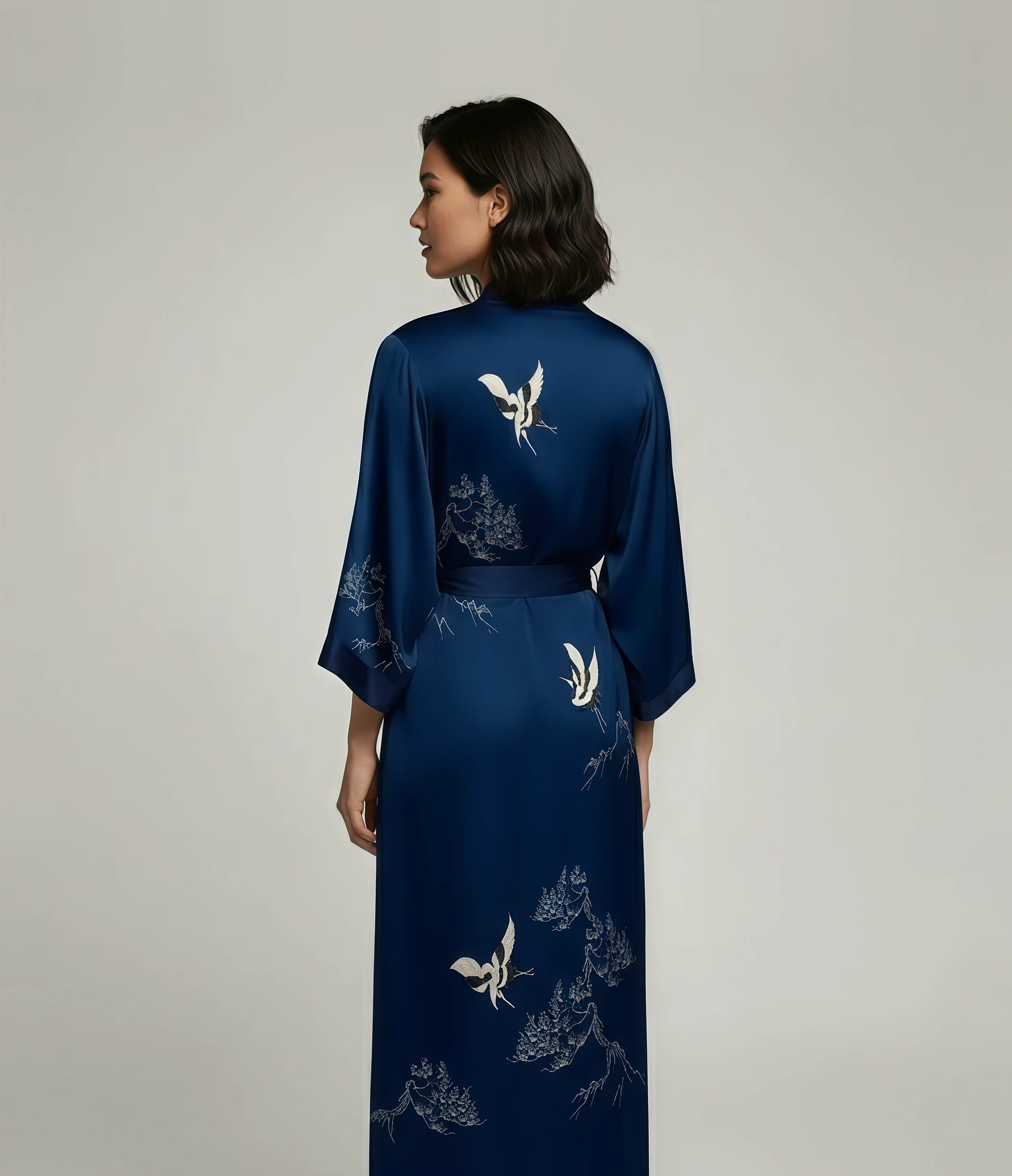 Back view of a blue Japanese kimono robe for women with white crane pattern, long elegant loungewear robe with belt.