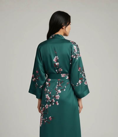 Back view of a green Japanese kimono robe for women with pink sakura cherry blossom print, long elegant loungewear robe with belt.