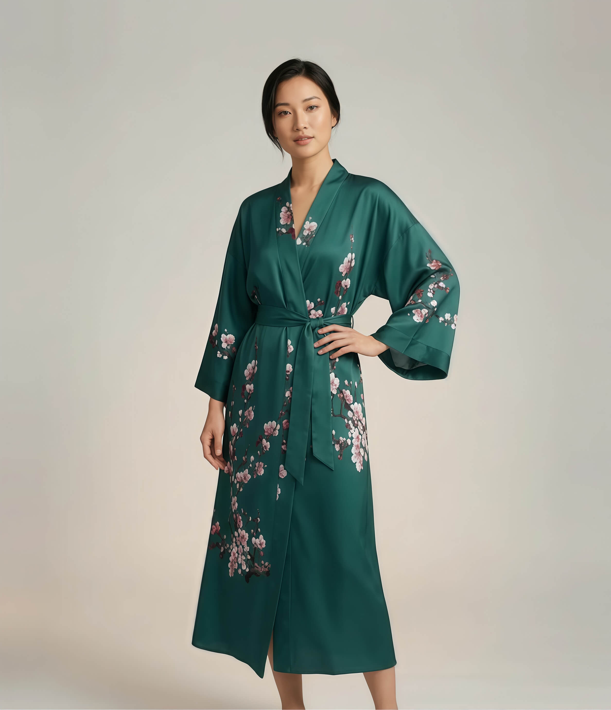 Front view of a green Japanese kimono robe for women with pink sakura cherry blossom print, long elegant loungewear robe with belt.