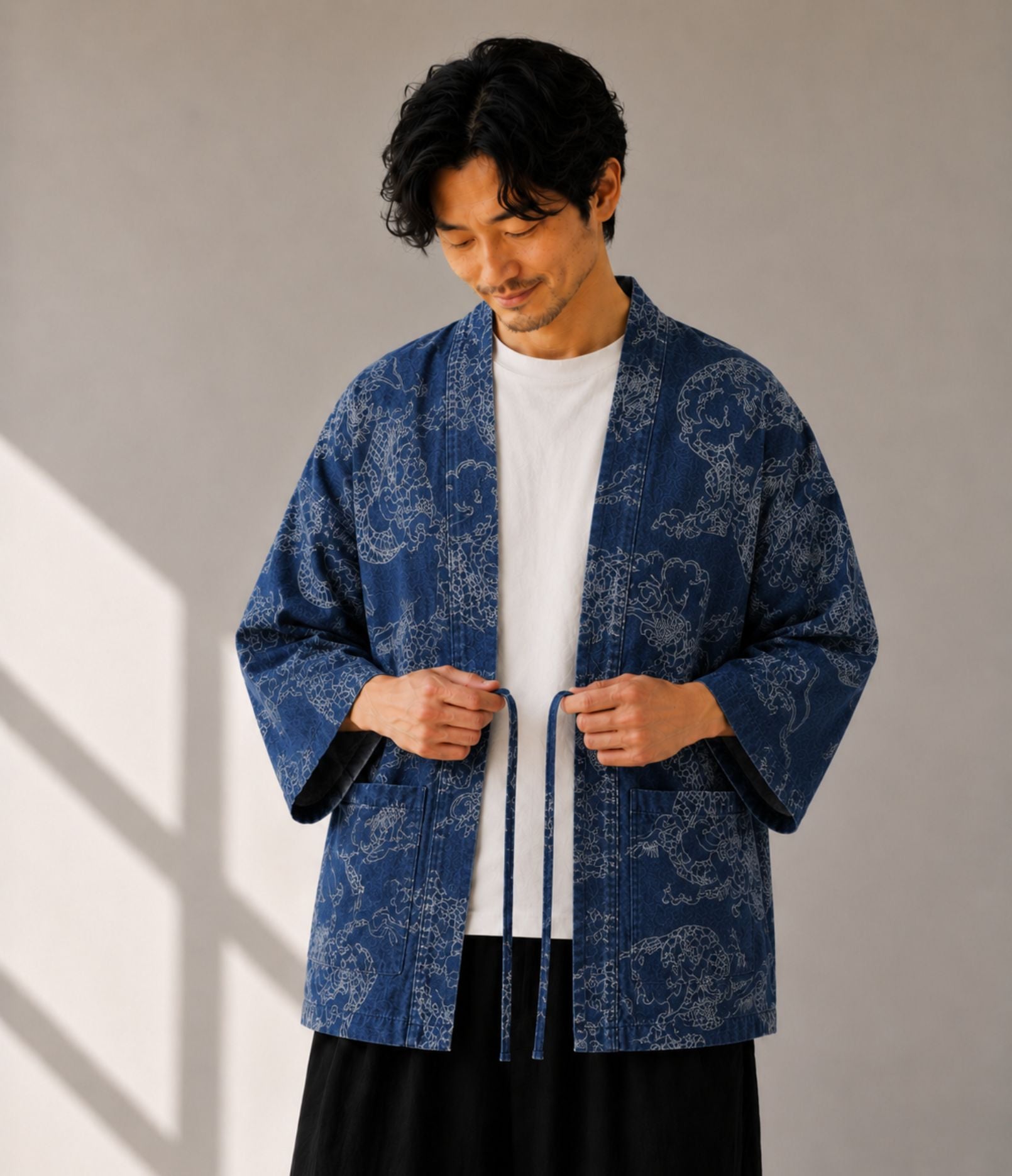 Man tying the cords on an indigo denim dragon-print haori jacket
