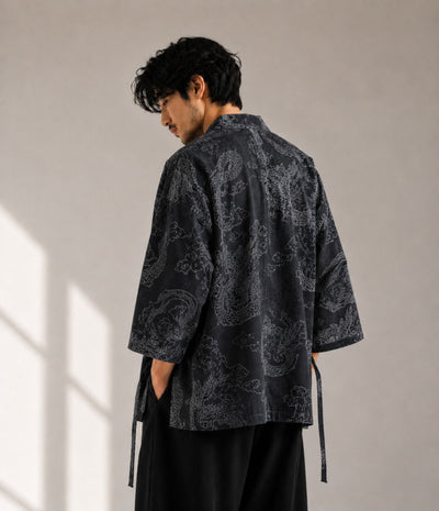 Back view of a man in a charcoal dragon-print kimono cardigan