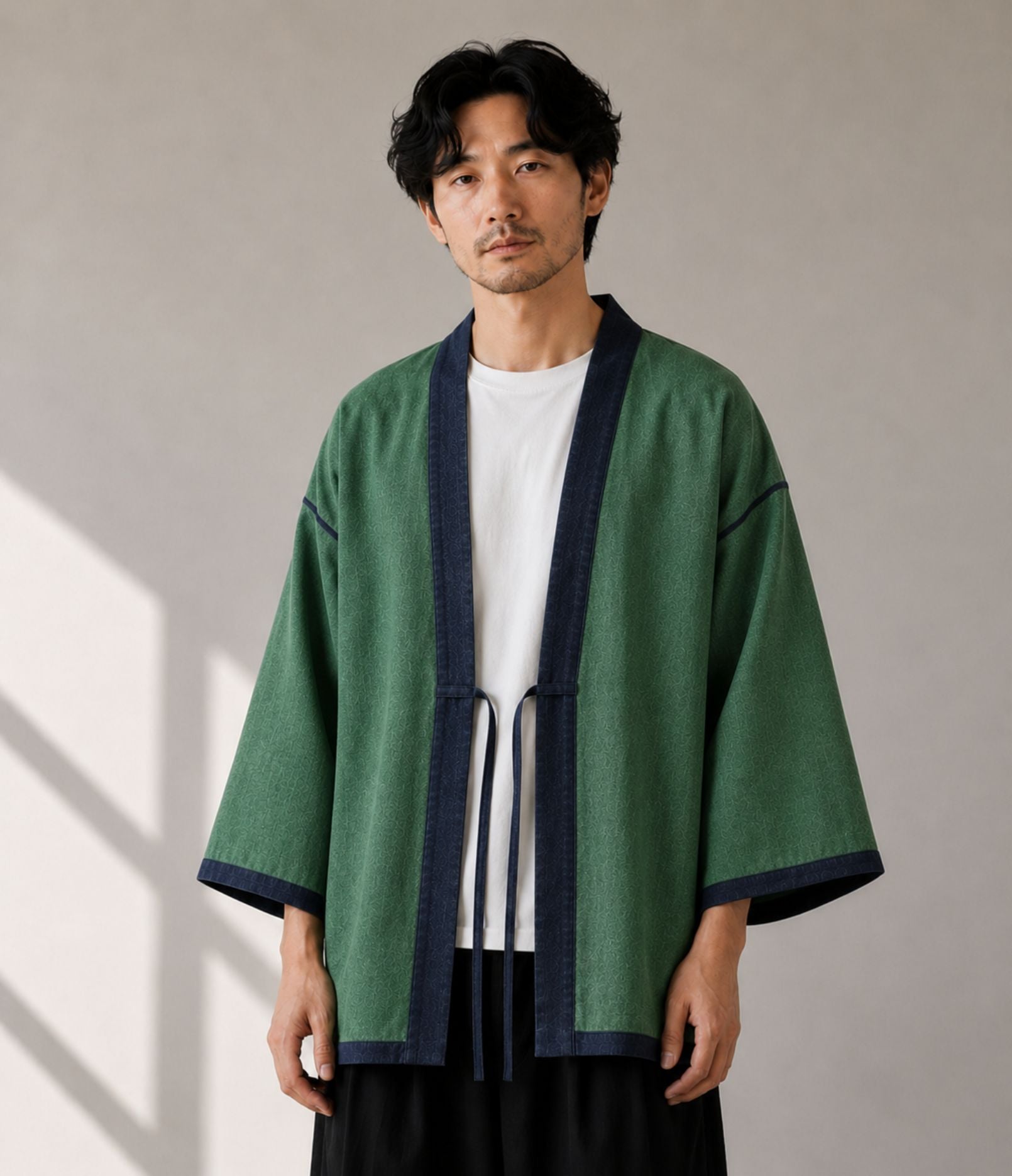 Man wearing a green haori jacket with navy trim and himo tie cords