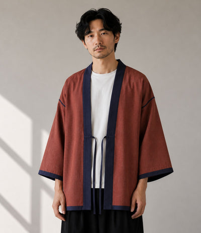 Man wearing a rust haori jacket with navy trim and himo tie cords