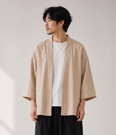 Man wearing a sand beige haori jacket open over a white tee