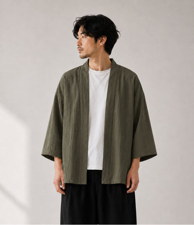 Man wearing an olive green noragi kimono cardigan over a white tee