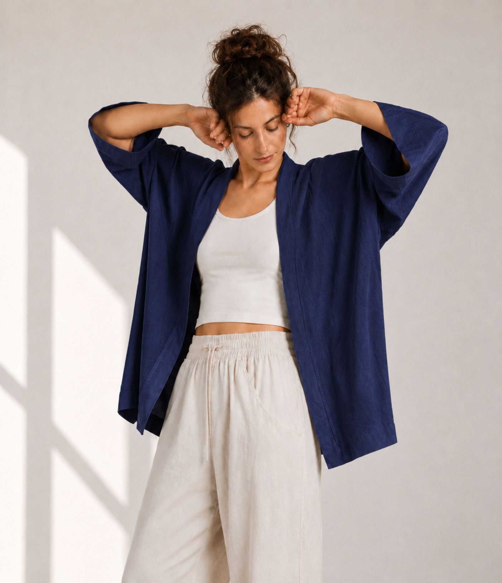 Woman showing the wide three-quarter sleeves of an indigo modern haori jacket