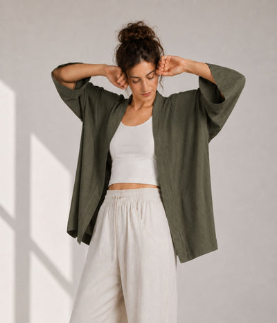 Woman showing the wide three-quarter sleeves of an olive green modern haori jacket