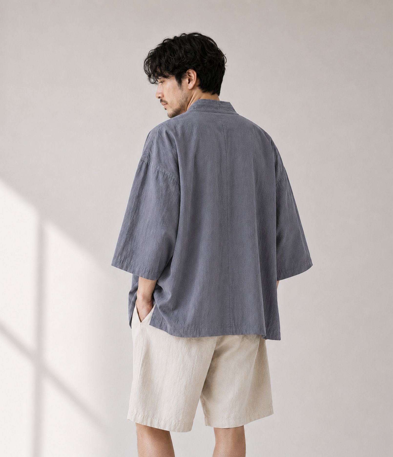 Back view of a man in an oversized grey Japanese kimono jacket