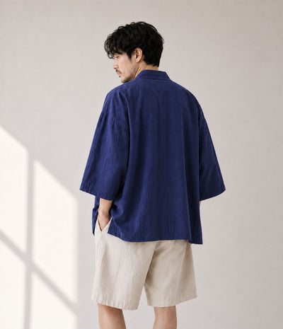 Back view of a man in an oversized indigo Japanese kimono jacket
