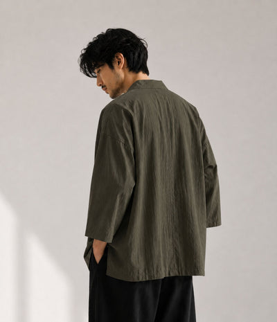Back view of a man in an oversized khaki Japanese kimono jacket