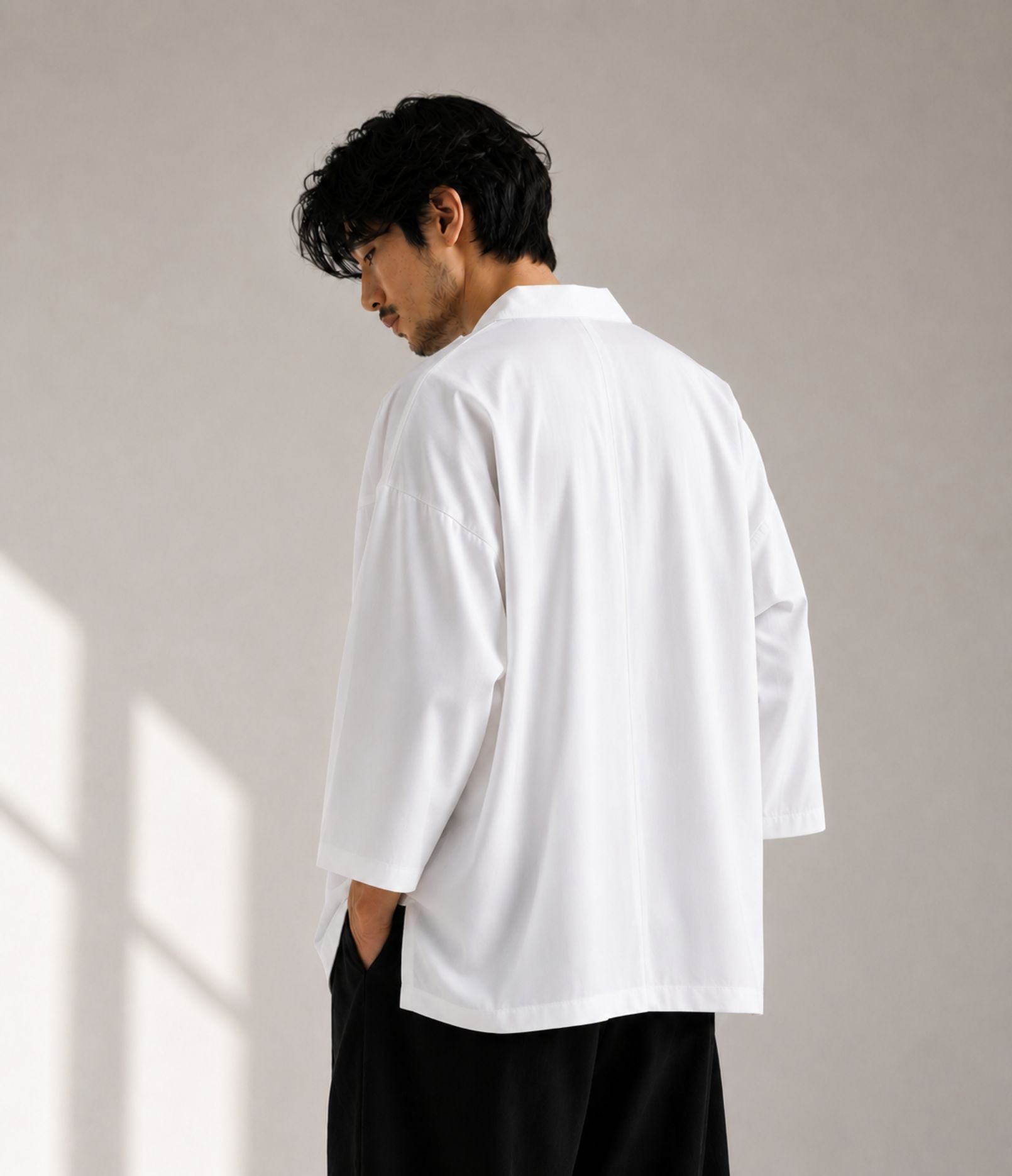 Back view of a man in an oversized white Japanese kimono jacket