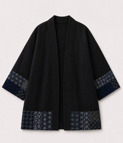 Black haori jacket with indigo patchwork print sleeve and hem trim, front