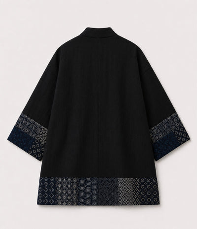 Back of a black kimono jacket with indigo sashiko-style patchwork trim