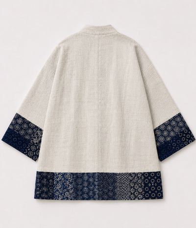 Back of a natural linen kimono jacket with indigo sashiko-style patchwork trim