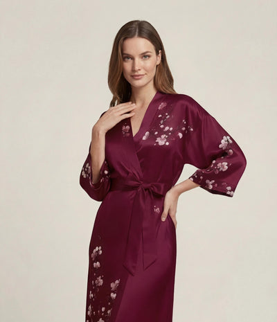 Front view of a red Japanese kimono robe for women with sakura cherry blossom print, long elegant loungewear robe with waist belt.