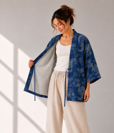 Woman opening an indigo denim dragon-print haori jacket to show grey lining