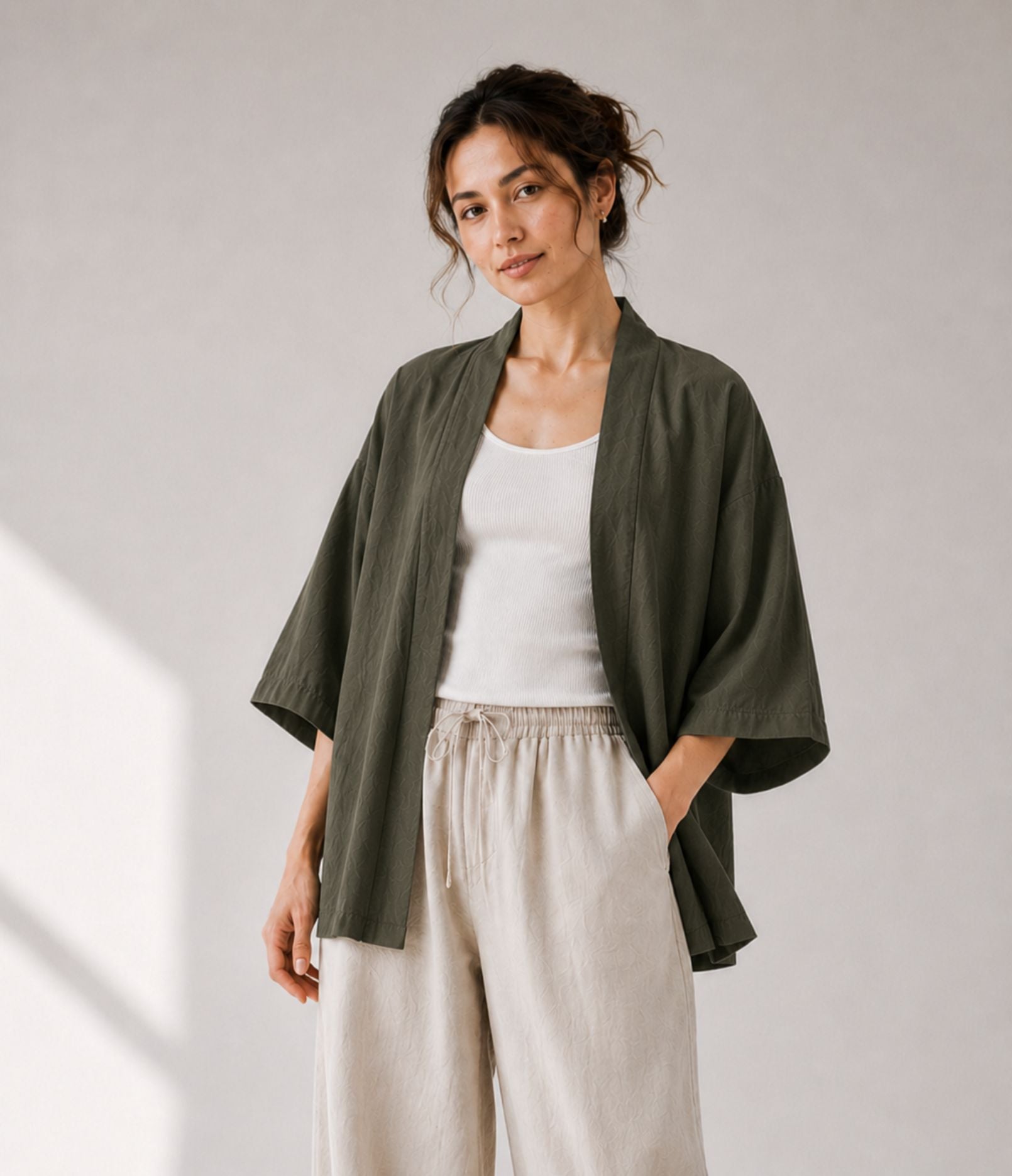 Woman wearing a lightweight olive green haori jacket over a white tank top
