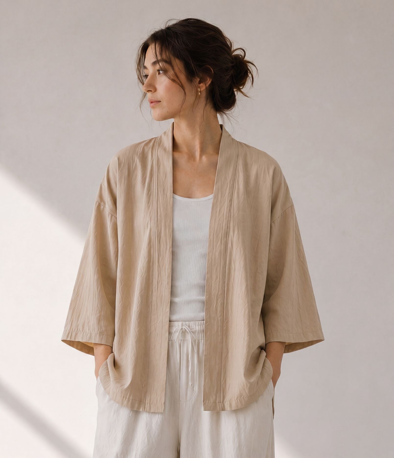 Woman wearing a sand beige haori jacket over a white tank top