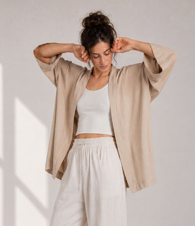 Woman showing the wide sleeves of a sand beige haori jacket