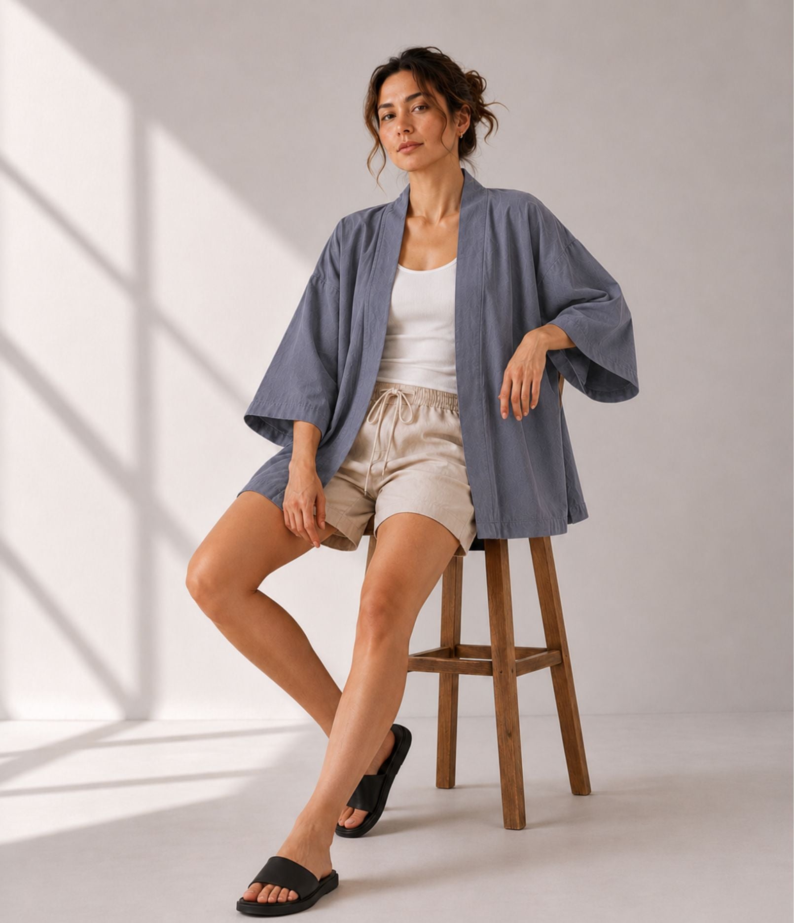 Woman in a grey open-front kimono cardigan, seated and styled for summer