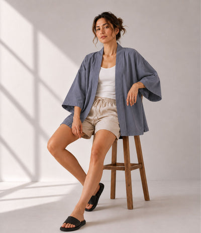 Woman in a grey open-front kimono cardigan, seated and styled for summer