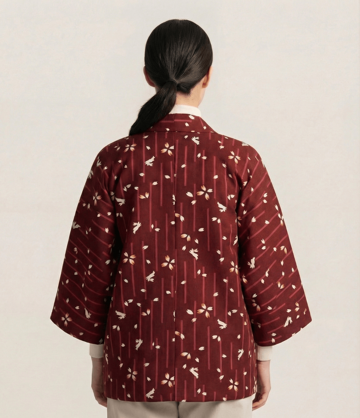 Back view of burgundy women’s Japanese hanten jacket featuring sakura blossom pattern